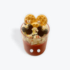 Cup with whipped cream, waffles, and Mickey Mouse-shaped cookies on a white background