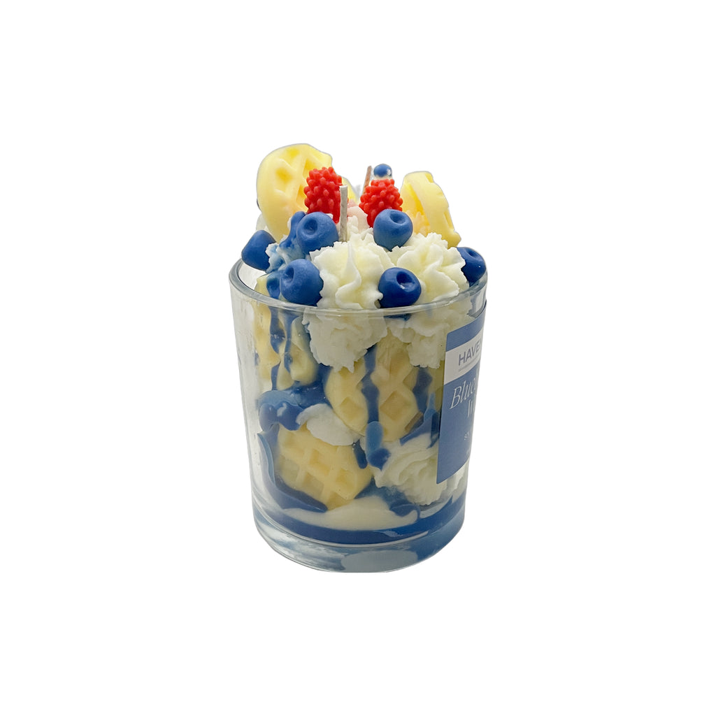 Fruit-themed candle in a glass container on a white background