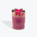 Pink candle with butterfly-shaped wick on a white background