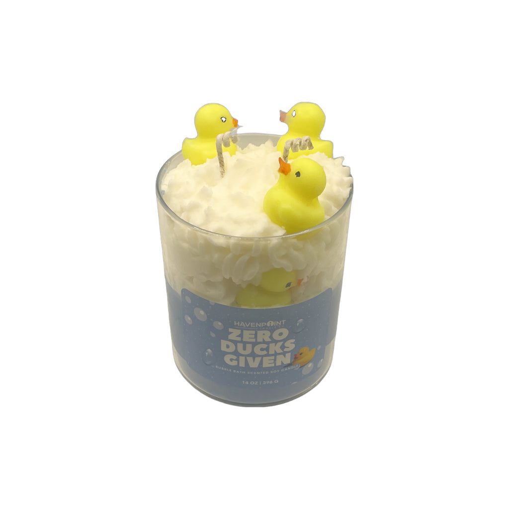 Glass candle with floating yellow rubber duckies and a blue label on a white background