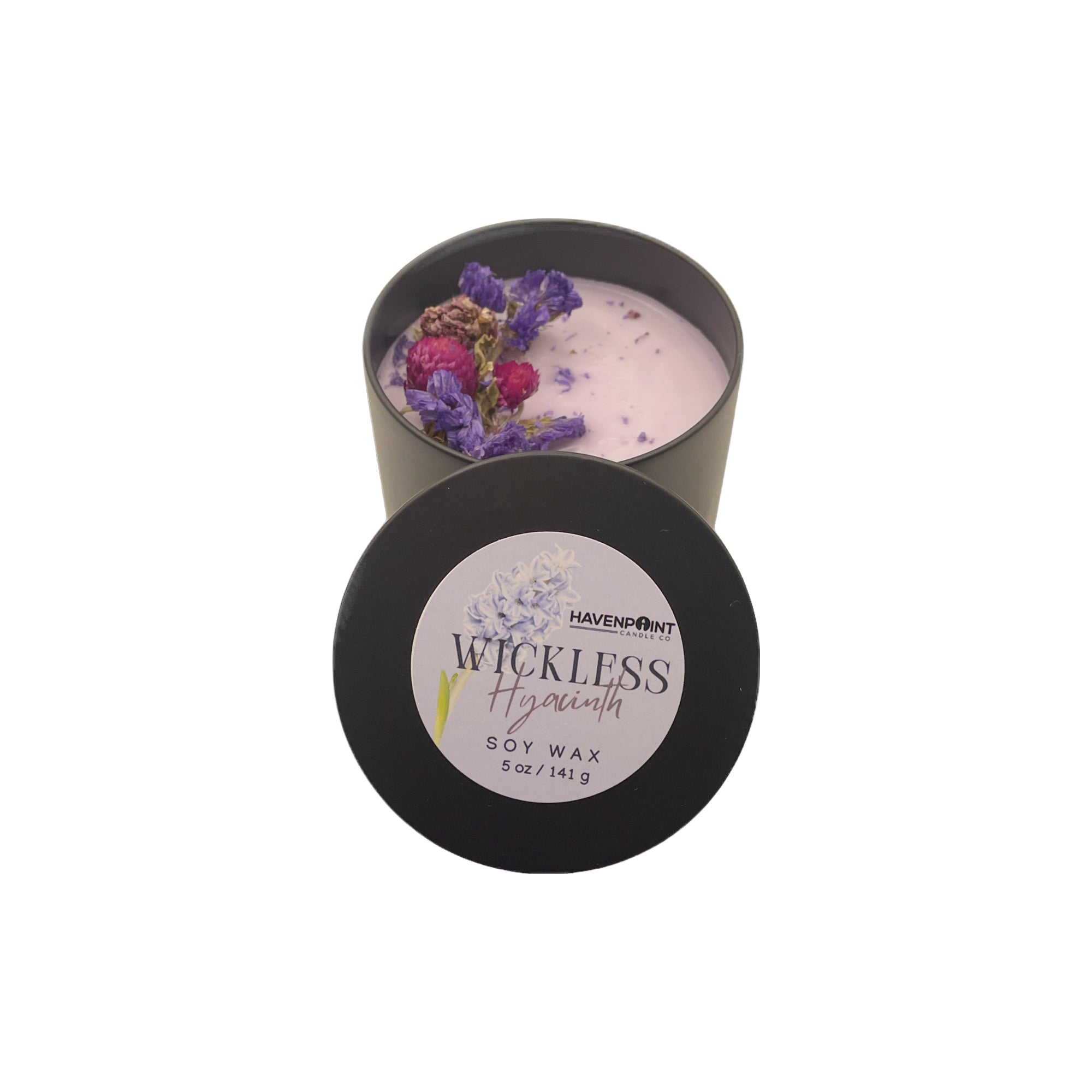 Candle in a black container with dried flowers on a white background