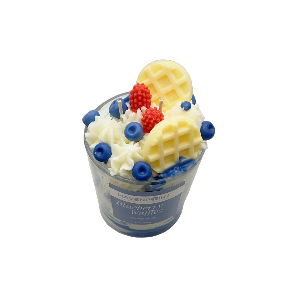 Candle in the shape of a blueberry waffle with waffle, blueberries, and strawberries on top, branded 'Havenpoint'.