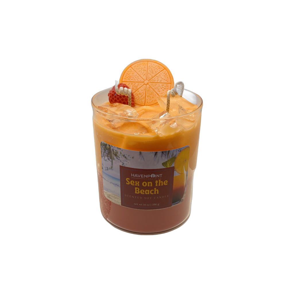 Candle in a glass jar with an orange slice and strawberry on top, labeled 'Sex on the Beach' by Haven Point.