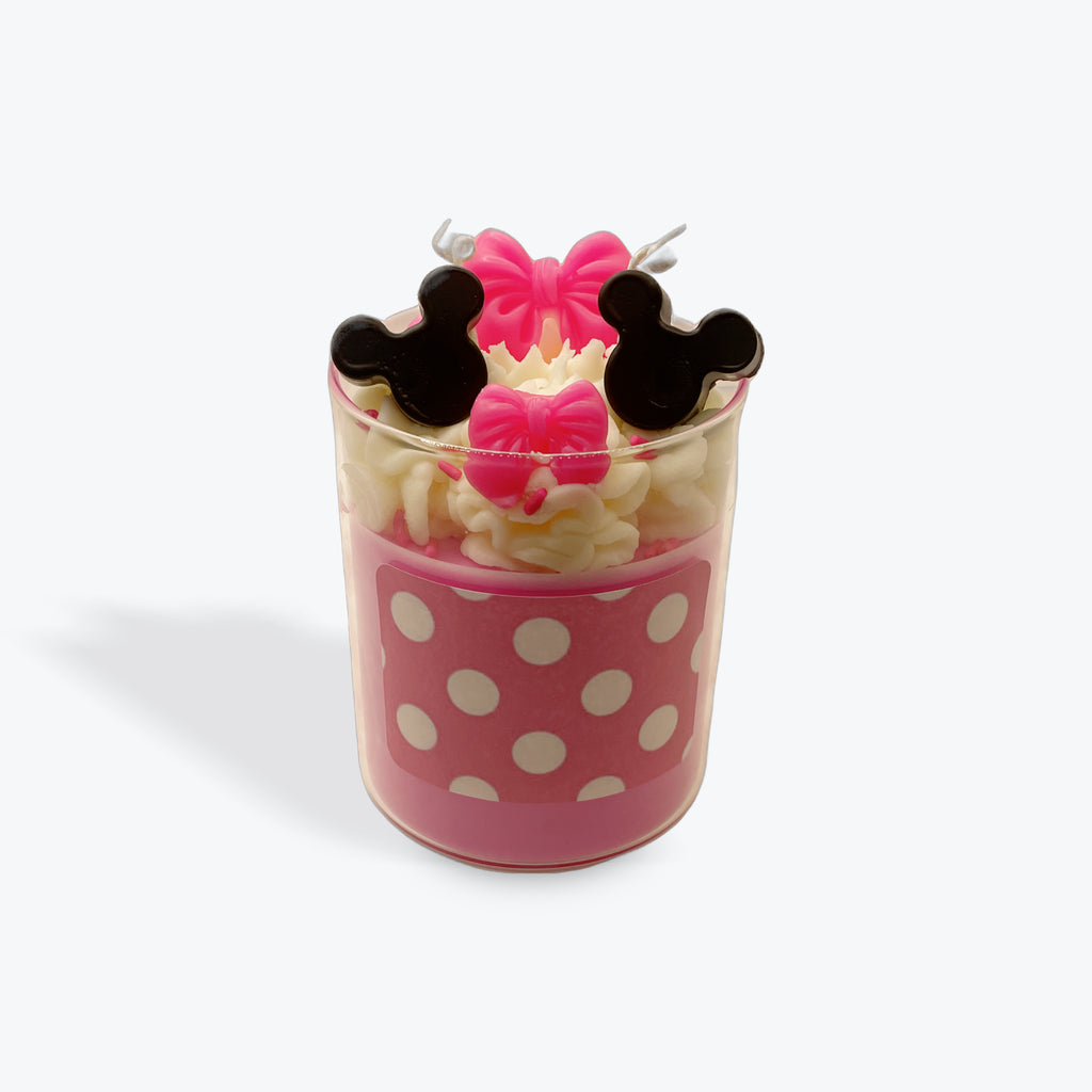 Pink polka dot cup with decorative candles on a white background