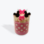 Pink polka dot cup with decorative candles on a white background